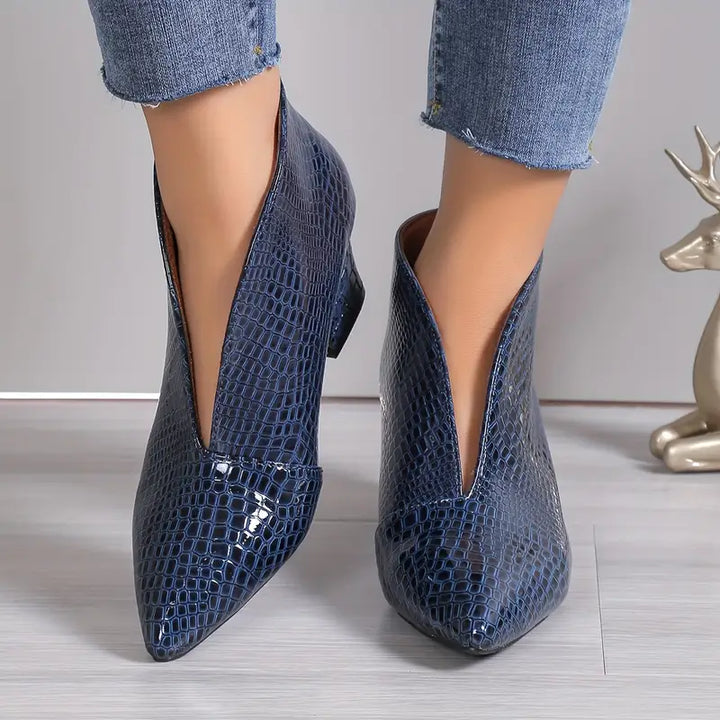 Blauwe enkellaarsjes met slangenprint, puntige neus en lage hak, gedragen met jeans. Modieuze dameslaarzen, trendy schoenen, herfstmode.