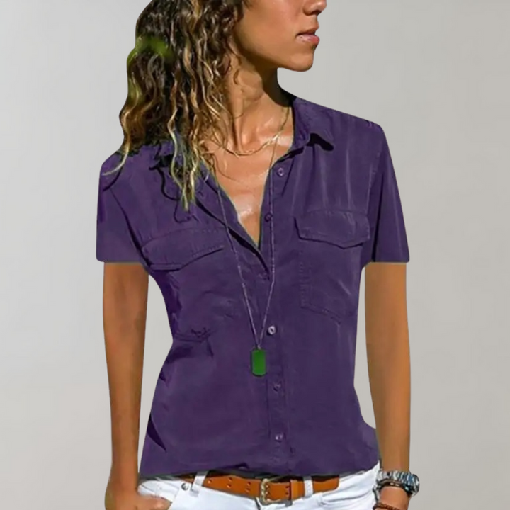 Paarse damesblouse met korte mouwen, knoopsluiting en borstzakken. Perfect voor casual en zakelijke outfits. Modieuze dameskleding.