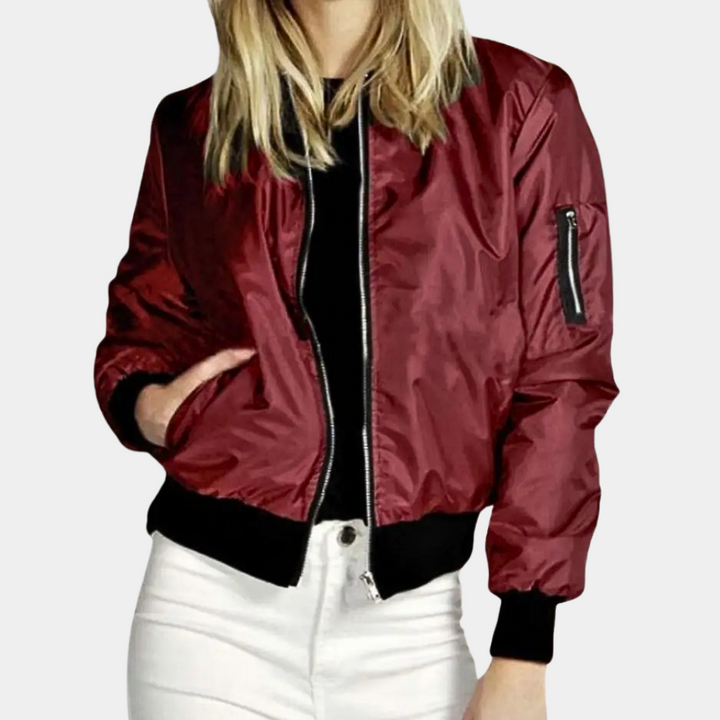 Rode dames bomberjack, glanzende stof, ritssluiting, zak op mouw, casual mode, herfstkleding, trendy jas voor dames, stijlvolle outfit.