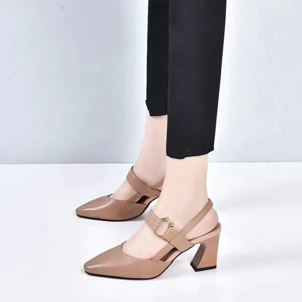 Beige leren dameshakken met blokhak en verstelbare band, gedragen met zwarte broek. Stijlvolle schoenen voor modebewuste vrouwen.