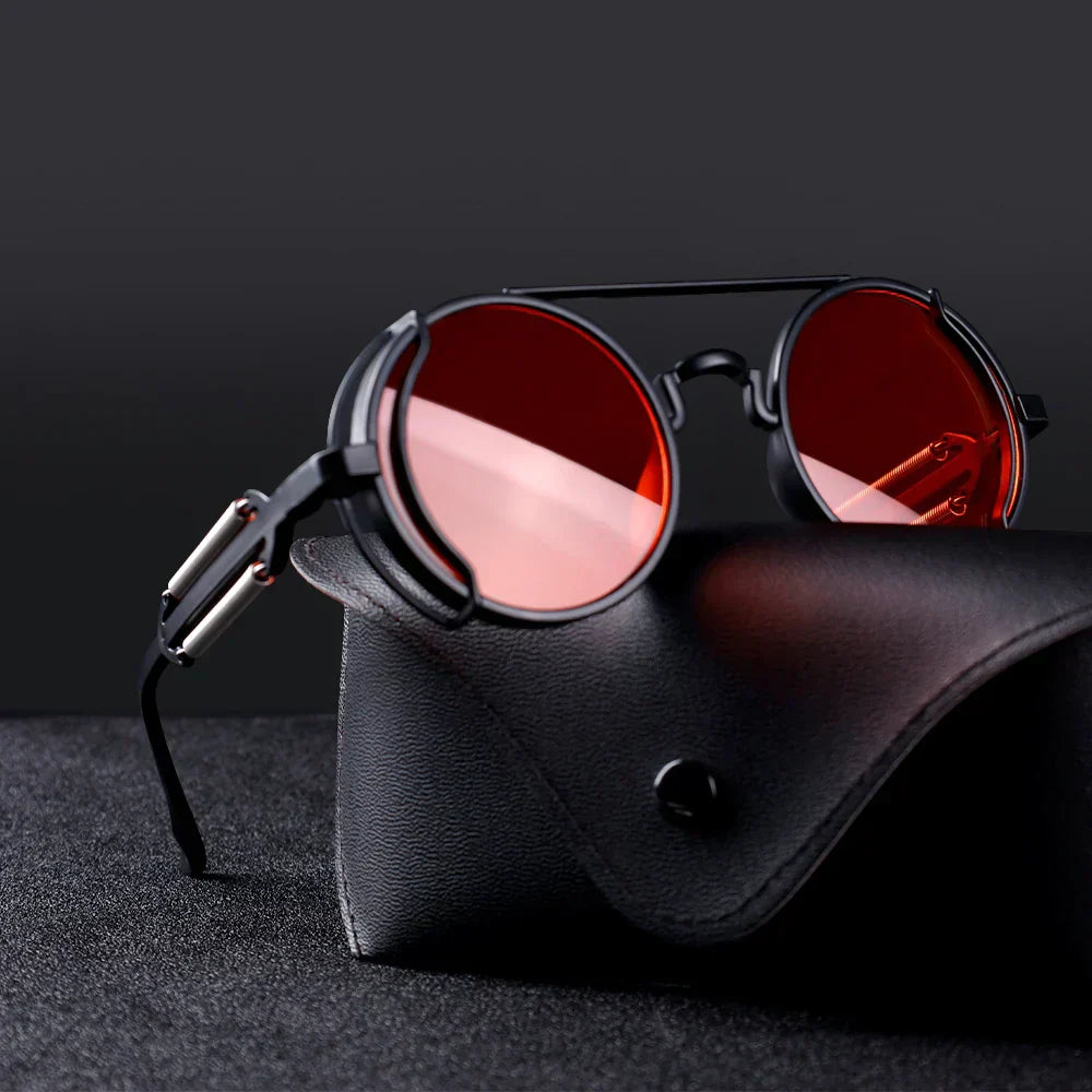 Ronde retro zonnebril met rode glazen op zwarte leren brillenkoker, stijlvolle vintage accessoire, modieuze unisex zonnebril.