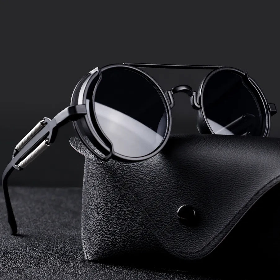 Ronde zwarte zonnebril met metalen frame op een zwarte leren brillenkoker, stijlvolle unisex accessoire, modieuze zonnebrillen voor heren en dames.
