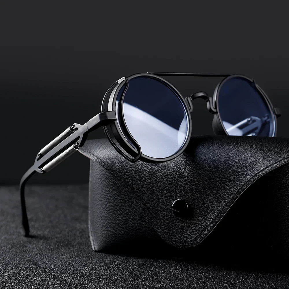Ronde zwarte zonnebril met metalen frame op een zwarte leren brillenkoker, stijlvolle unisex zonnebril, modieuze accessoires, UV-bescherming.