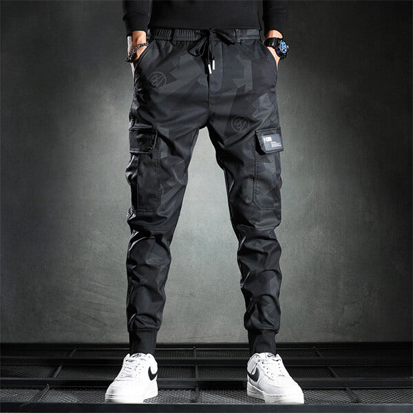 Zwarte cargo joggingbroek voor heren met zakken, sportief design, comfortabele pasvorm, ideaal voor casual en streetwear, gecombineerd met witte sneakers.