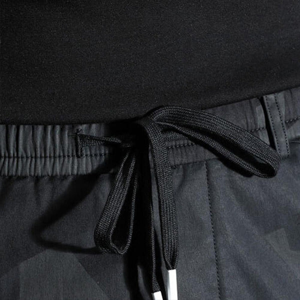 Zwarte sportbroek met elastische tailleband en trekkoord, close-up. Comfortabele en stijlvolle trainingsbroek voor heren. Perfect voor fitness en casual wear.