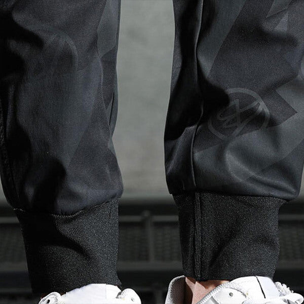Zwarte sportbroek met elastische boorden, gedragen met witte sneakers. Modieuze streetwear, comfortabele pasvorm, ideaal voor casual en sportieve looks.