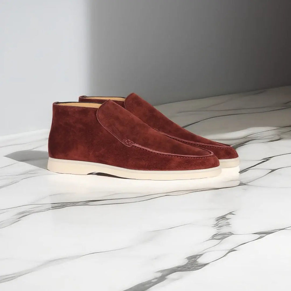 Bruine suède herenschoenen op marmeren vloer, stijlvolle enkellaarzen met witte zolen, moderne herenschoenmode, casual en elegant ontwerp.