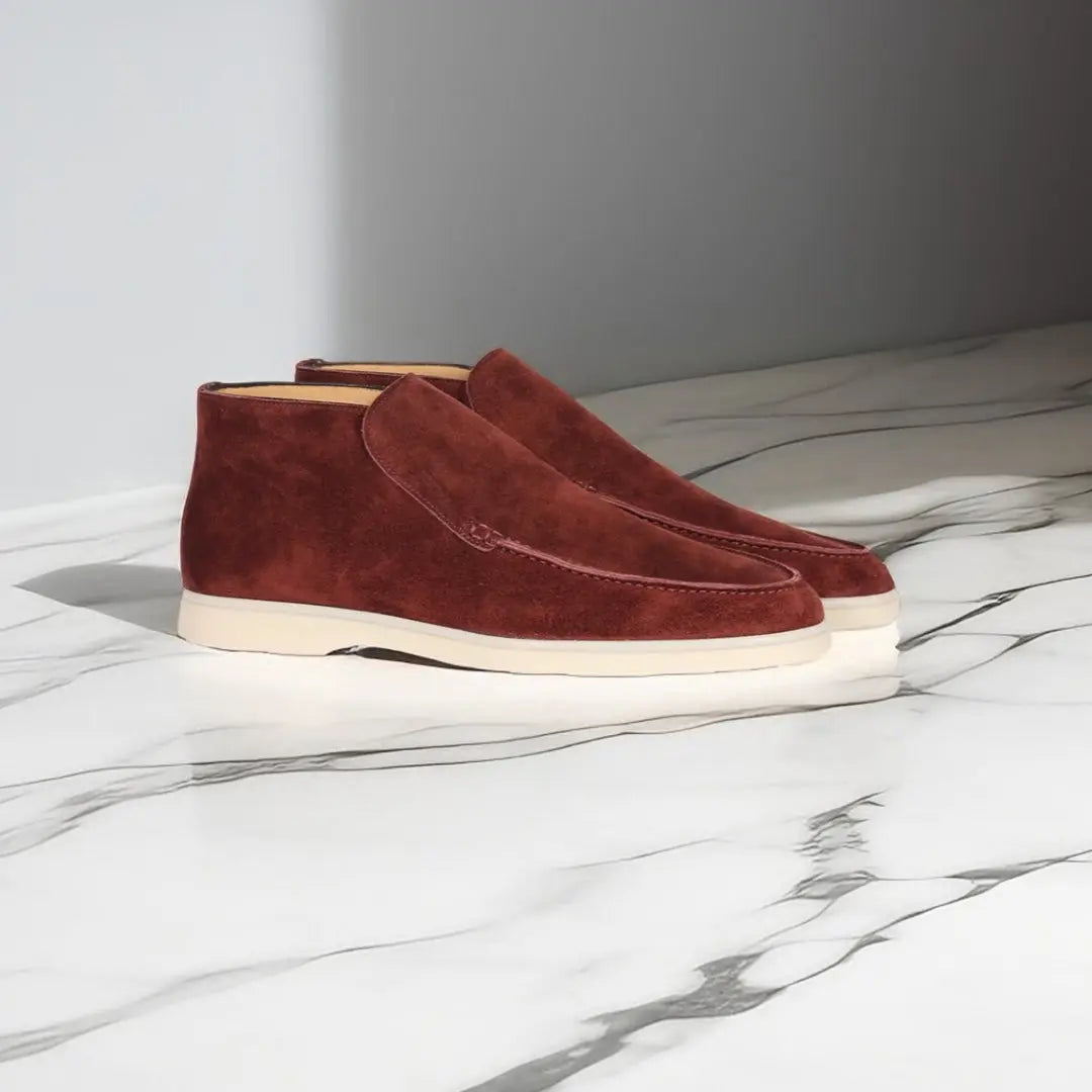 Bruine suède herenschoenen op marmeren vloer, stijlvolle enkellaarzen met witte zolen, moderne herenschoenmode, casual en elegant ontwerp.