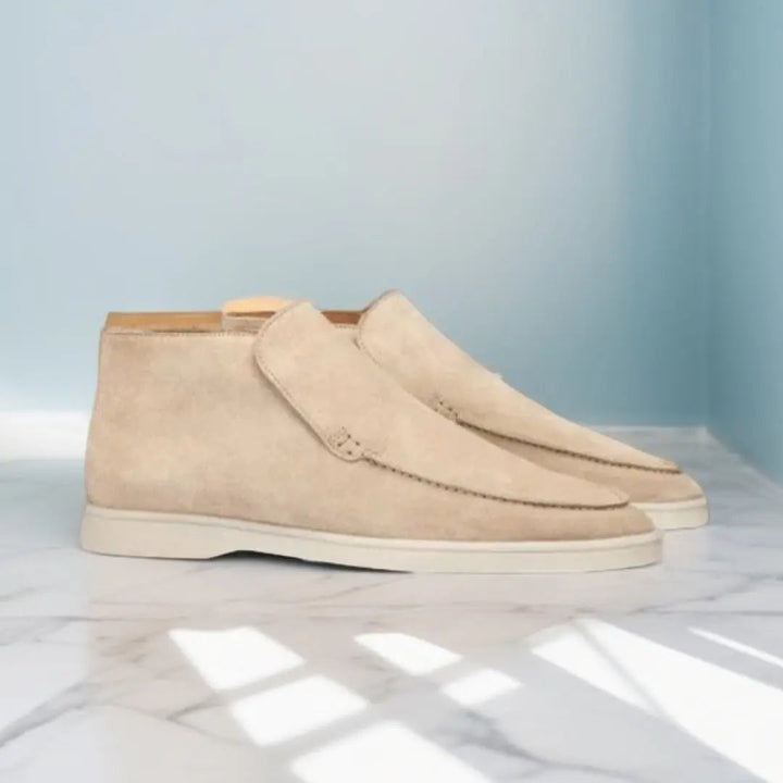 Beige suède herenschoenen op marmeren vloer, stijlvolle casual schoenen, zijaanzicht, moderne mode, lichtblauwe achtergrond.