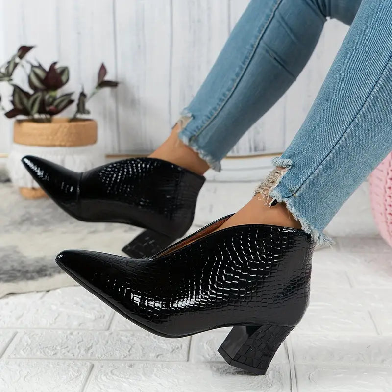 Zwarte leren enkellaarsjes met krokodillenprint en blokhak, gedragen met blauwe skinny jeans. Stijlvolle damesmode, trendy schoenen.